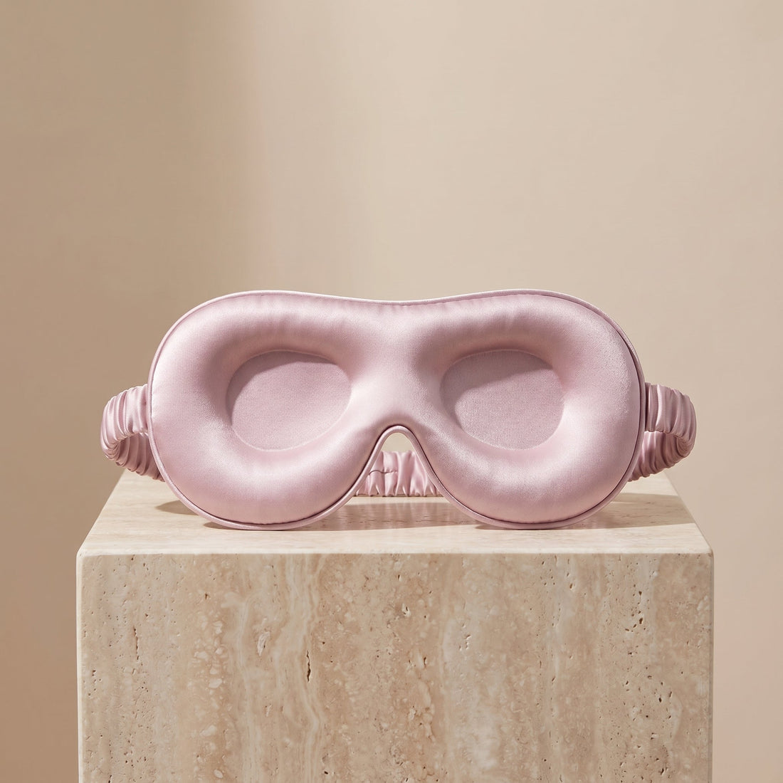 DreamZen silk sleep mask on a folded blanket set up for a calm evening routine