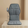 ChairZen gray velvet massage chair pad upright on a travertine pedestal in soft studio light