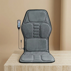 ChairZen gray velvet massage chair pad upright on a travertine pedestal in soft studio light