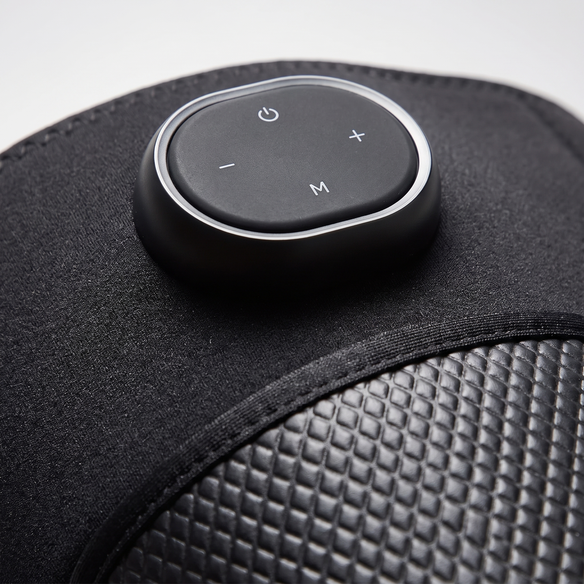 Close-up of the KneeZen control pod on the smooth neoprene above the quilted panel
