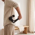PulseZen Pro massage gun used on the lower back