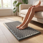 Feet resting on the grey AcuZen acupressure spike mat