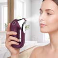 Woman misting her face with the wine-purple HydraZen facial sprayer