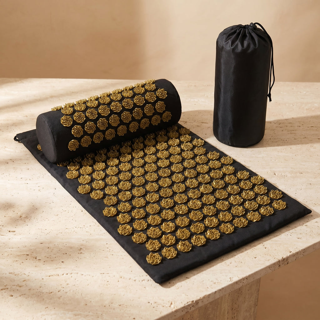 AcuZen acupressure mat pillow and bag in gold on a travertine pedestal