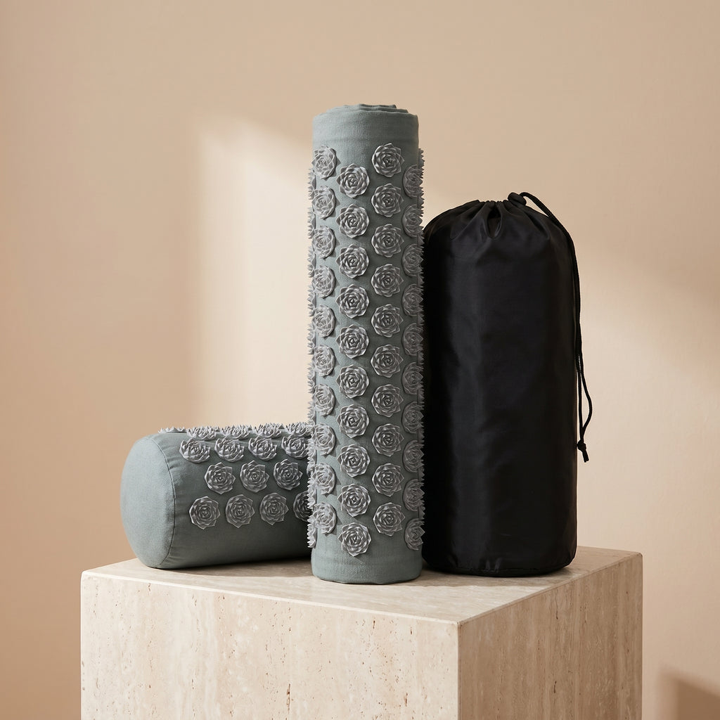 Gray AcuZen recovery mat rolled beside its bolster pillow and carry bag