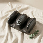 CalfZen foot massager boot on cream linen with eucalyptus sprig overhead angle