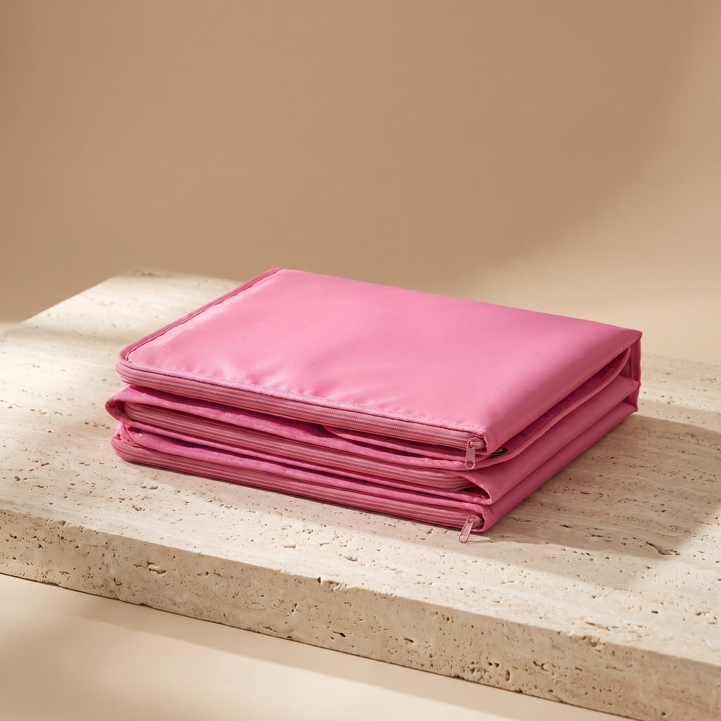 CocoonZen infrared sauna blanket in pink folded on travertine surface