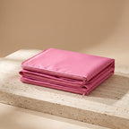 CocoonZen infrared sauna blanket in pink folded on travertine surface