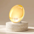 DawnZen sunrise alarm clock on a light travertine stone pedestal with warm beige backdrop
