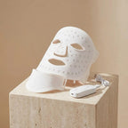 Zenyzen GlowZen Neck LED mask in white on a travertine stone pedestal