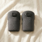 KneeZen knee massager pair flat lay on soft cream linen in airy natural daylight