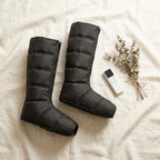 LegZen massager boots laid flat on cream linen fabric with eucalyptus sprigs
