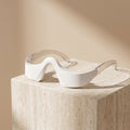 LumiZen eye massager resting on a travertine stone block