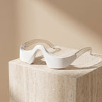LumiZen eye massager resting on a travertine stone block