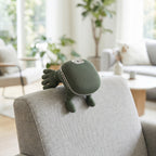 NeckZen neck massager resting on back of gray armchair in living room