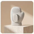 PalmZen hand massager glove upright on travertine pedestal beige studio