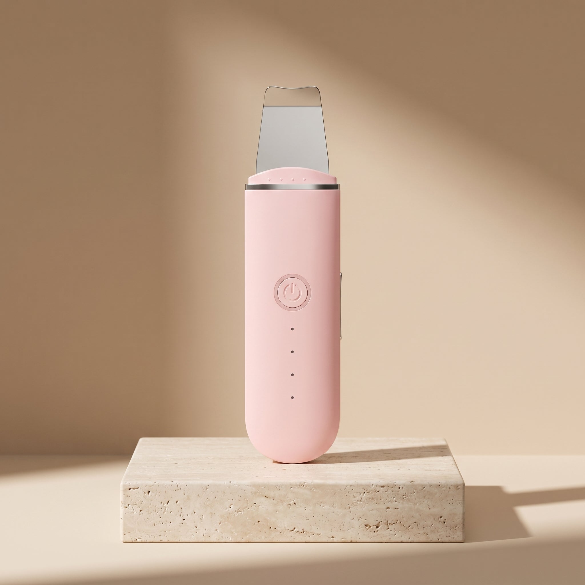 PoreZen sonic skin scrubber in pink on a travertine stone pedestal