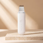 White PoreZen sonic scrubber standing upright in soft warm daylight