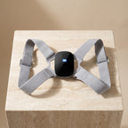 PostureZen smart posture trainer with black module on a travertine pedestal