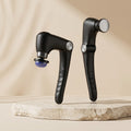 PulseZen Pro heated percussion massage gun on light travertine pedestal with warm beige backdrop