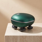 Green ScalpZen head massager standing on a travertine display block