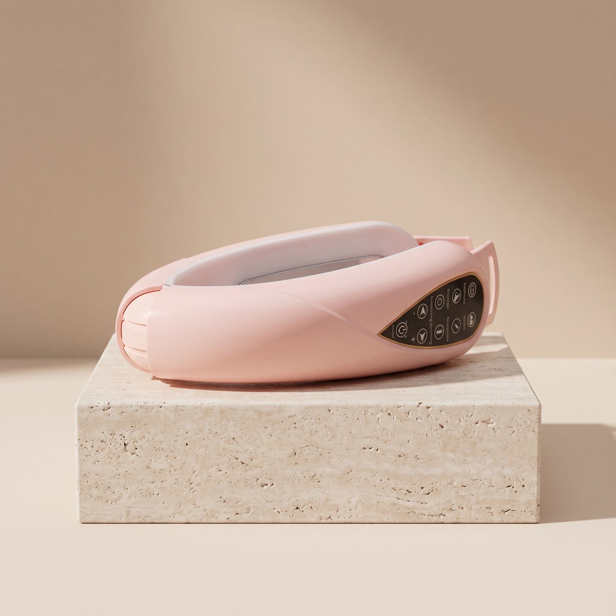 Pink SculptZen face sculpting device resting on a travertine block