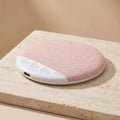 SnoozeZen under-pillow speaker in blush pink on travertine pedestal