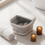 SoakZen foot spa tub on bathroom floor tiles with towel and candle