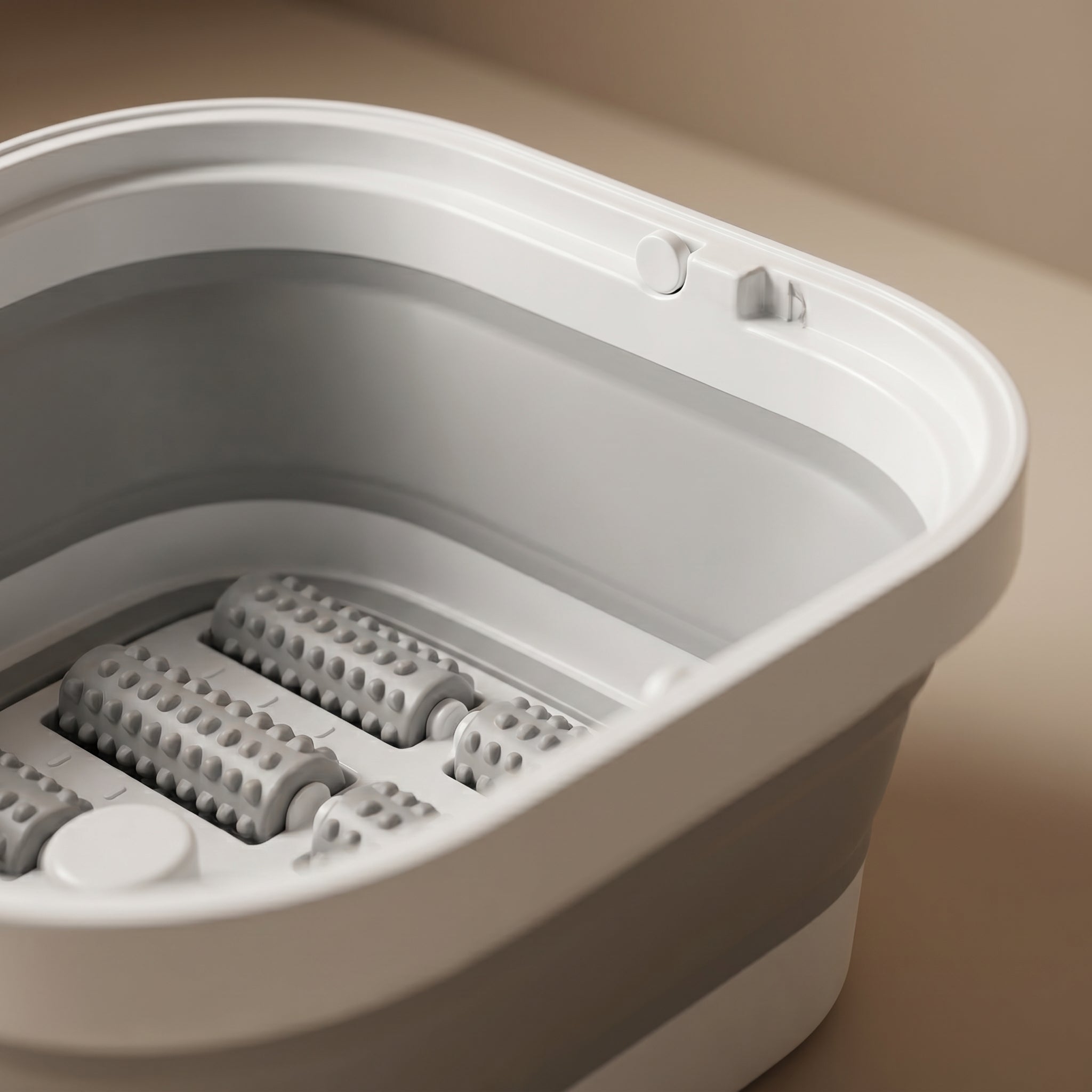 Close-up of SoakZen massage rollers and control button inside basin