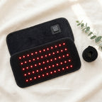 ThermaZen therapy pad lying on cream linen beside its strap