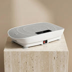 VibeZen compact vibration plate on travertine pedestal warm studio light