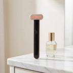 WandZen face wand on white marble vanity surface beside small glass bottle